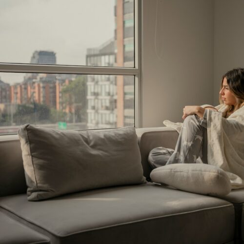 woman at home with blanket wrapped around her